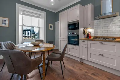 a kitchen with a table and chairs in a kitchen at GuestReady - Charming home in Edinburgh in Edinburgh