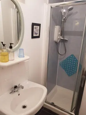 a white bathroom with a shower and a sink at Maridon House in Oban
