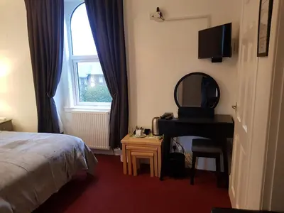 a bedroom with a bed and a mirror and a desk at Maridon House in Oban