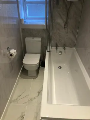 a bathroom with a white tub and a toilet at Maridon House in Oban