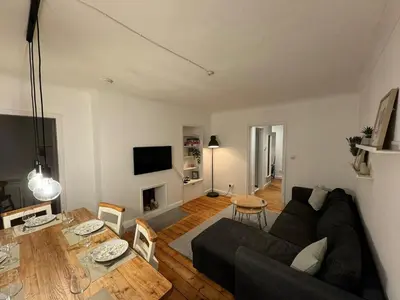 a living room with a black couch and a table at Stirling Haven: Charming 3B Apt in City Centre in Stirling