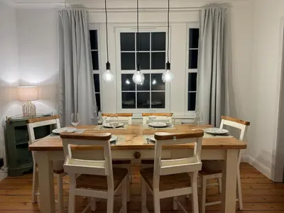 a dining room with a wooden table and chairs at Stirling Haven: Charming 3B Apt in City Centre in Stirling
