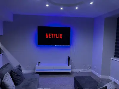 a living room with a netflix sign on a wall at Modern 3-Bedroom Home with Cozy Cinema-Style Living Space in Cumbernauld