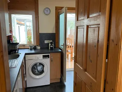 a kitchen with a washing machine and a sink at Mountain View House Kinlochleven in Kinlochleven