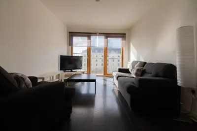 a living room with two couches and a television at Argyle Apartment in Glasgow