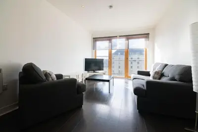 a living room with two couches and a television at Argyle Apartment in Glasgow