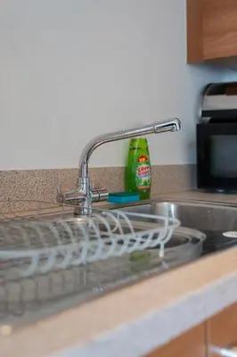 a kitchen sink with a dish drying rack next to it at Argyle Apartment in Glasgow