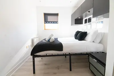 a bedroom with a bed with a black and white mattress at Argyle Apartment in Glasgow