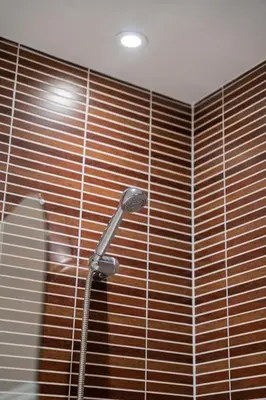 a shower in a bathroom with a wooden wall at Argyle Place in Glasgow