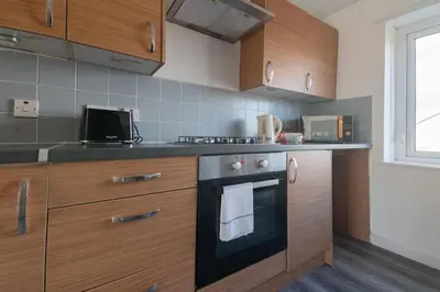 a kitchen with wooden cabinets and a stove at Renfrew House in Renfrew