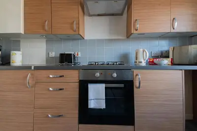 a kitchen with a black oven and wooden cabinets at Renfrew House in Renfrew