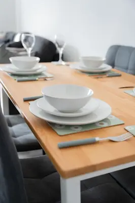 a wooden table with white bowls and plates on it at Renfrew House in Renfrew