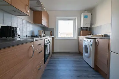 a kitchen with a washing machine and a window at Renfrew House in Renfrew