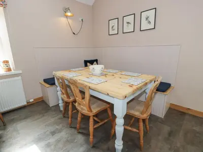 a dining room table with chairs and a bowl on it at Morton Mains Steading Cottage in Thornhill