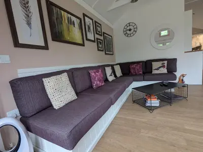 a living room with a purple couch and a table at The Dochart Lodge with hot tub Braidhaugh Crieff in Crieff