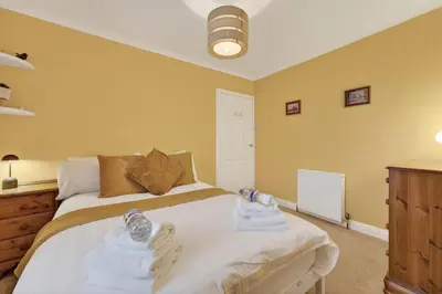 a bedroom with a bed with towels on it at The Bruadair - Modern Town Living in Ardrossan