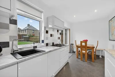 a kitchen with a sink and a window and a table at The Bruadair - Modern Town Living in Ardrossan