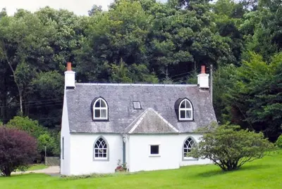 a white house with a gray roof at Foresters Cottage, Dalry in Dalry