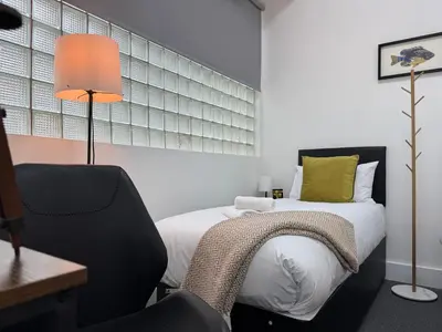 a bedroom with a bed and a desk and a chair at Squarezzz - Group Accommodation in Edinburgh