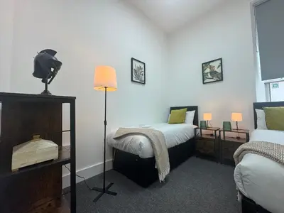 a room with two beds and a lamp in it at Squarezzz - Group Accommodation in Edinburgh