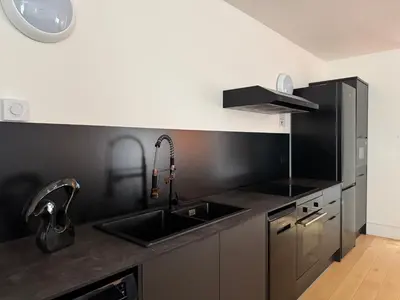 a kitchen with a sink and a black counter top at Squarezzz - Group Accommodation in Edinburgh