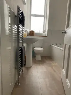 a bathroom with a sink and a toilet and a window at Spacious 3 bedroom apartment in Campbeltown centre in Campbeltown