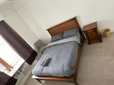 a bed in a small room with a window at Spacious 3 bedroom apartment in Campbeltown centre in Campbeltown