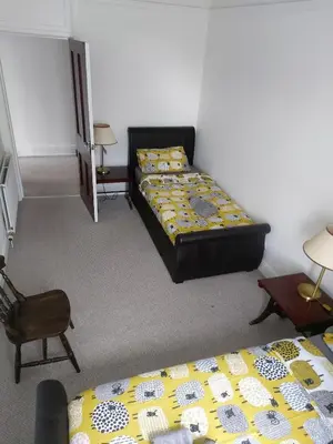 a room with two beds and a chair at Spacious 3 bedroom apartment in Campbeltown centre in Campbeltown