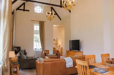 a living room with a couch and a tv at The Dower House at Solsgirth Home Farm in Dollar