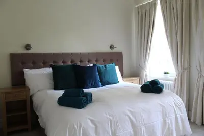 a bedroom with a bed with blue pillows on it at The Dower House at Solsgirth Home Farm in Dollar