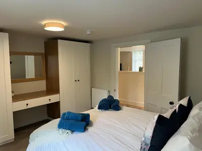 a bedroom with a large bed with blue towels on it at The Butler's Flat at Solsgirth Home Farm in Dollar