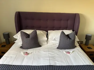 a large bed with two pillows on top of it at The Loch Lomond But n Ben in Gartocharn