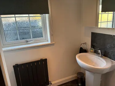 a bathroom with a sink and a window at The Loch Lomond But n Ben in Gartocharn