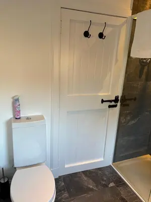 a white bathroom with a toilet and a shower at The Loch Lomond But n Ben in Gartocharn