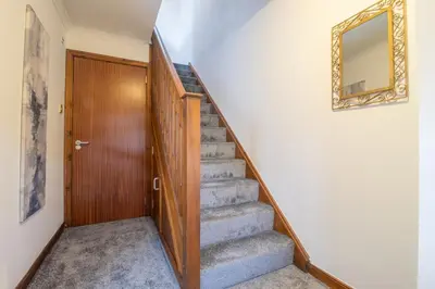a stairway with a mirror and a door at Ideal Contractor Stay 2-Bed Near Glasgow Fort in Garthamlock
