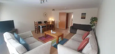 a living room with two white couches and a table at Apartment in Heart of West End- Parking Space- Spacious- Near Glasgow University and Kelvingrove Art Gallery in Glasgow
