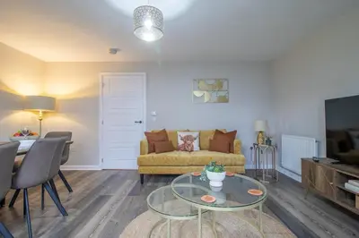 a living room with a couch and a table at Lendrick House-Spacious 3 Bed House in Falkirk in Polmont