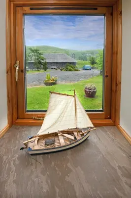 a model boat sitting in front of a window at Clan Cottages Luxury Thatched Retreat near Oban in Oban