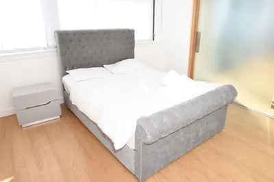 a bed in a room with a white bedvisor at Glasgow Hydro Apt with Great Views in Glasgow