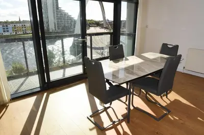 a table and chairs in a room with a large window at Glasgow Hydro Apt with Great Views in Glasgow