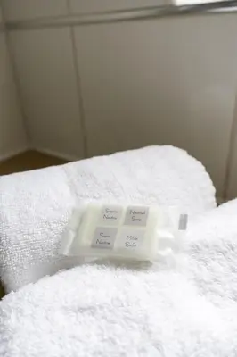 a pile of white towels on top of a bed at Riverview House in Glasgow