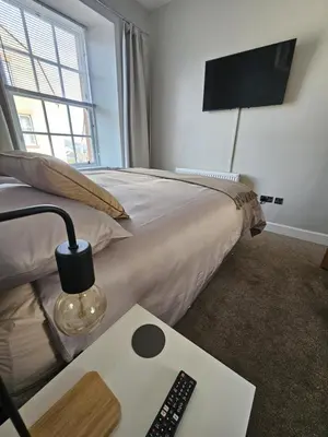 a bedroom with a bed with a television and a remote control at Ocean View 2 in Campbeltown