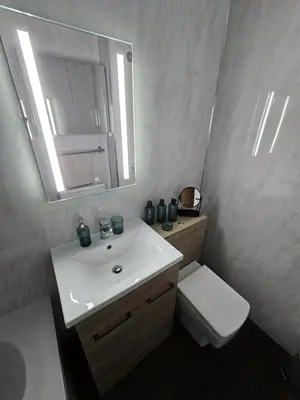 a bathroom with a sink and a toilet and a mirror at Ocean View 2 in Campbeltown