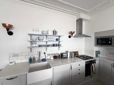a white kitchen with a sink and a stove at Bay View Cottage in Fairlie