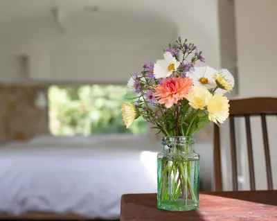a vase filled with flowers sitting on a table at Luxury Airstream Getaway with Sauna and Hot Tub in Gartness