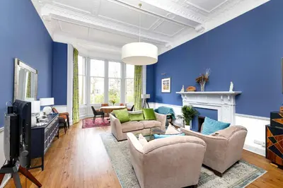 a living room with blue walls and a tv at JOIVY Spacious 2-Bedroom Ground Floor Flat in Edinburgh