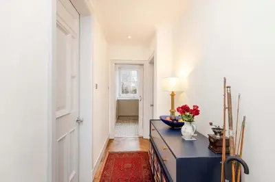 a hallway with a table with a vase of flowers on it at JOIVY Spacious 2-Bedroom Ground Floor Flat in Edinburgh