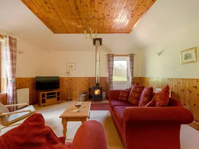 a living room with a couch and a tv at Holiday Home Doonans Cottage by Interhome in Straiton