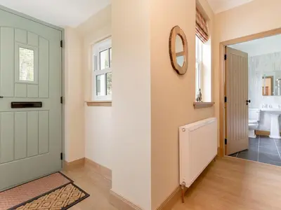 a hallway with a green door and a mirror at Holiday Home Balbeg Cottage by Interhome in Straiton