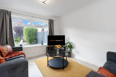 a living room with a tv on a table at Vacant Nests The Livingston Retreat Wi-Fi in Uphall